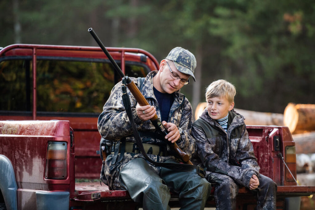 A father teaches his son firearm safety